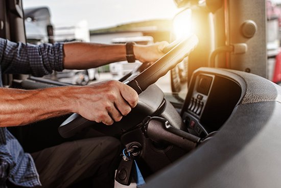Truck driver with hands on steering wheel